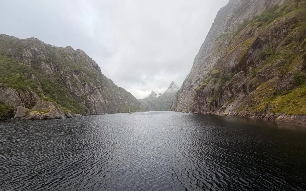 The narrow arm of Trollfjord in the Lofoten Islands, with a small boat between its steep rock walls